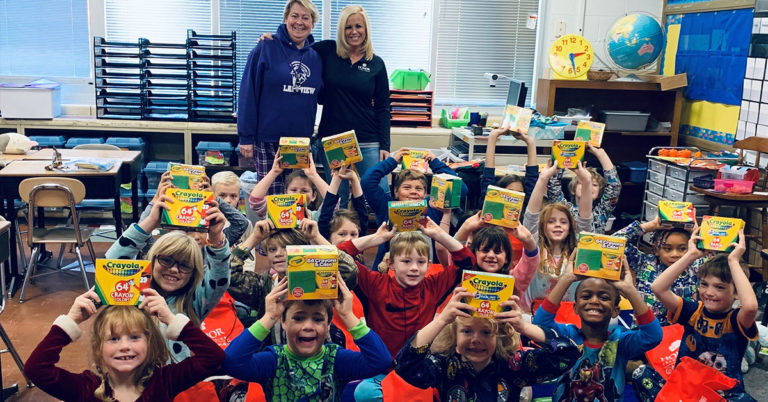 honor credit union announced 40 teacher award winners for 2019; group of students holding boxes of crayons in a classroom