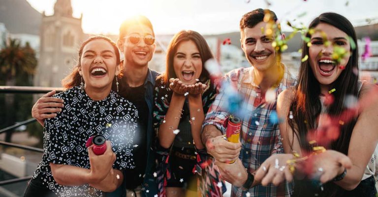 photo of a group of people gathered around a table smiling and celebrating