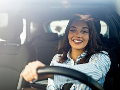 woman smiling while driving a car